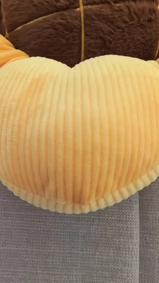 Un coussin en cœur jaune rayé